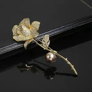 Exquisite gold rose flower brooch with sparkling cubic zirconia crystals and elegant pearl.