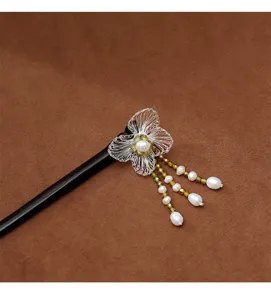 Vue détaillée de la fleur tissée main et des glands en perles sur pic à cheveux en ébène