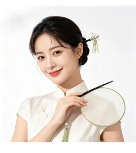 Vue détaillée de l'épingle à cheveux en ébène avec fleur et pompon dans un chignon