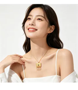 Close-up of gold square pendant necklace with evil eye pattern on a female model.