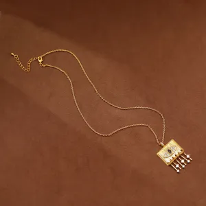 Geometric gold pendant necklace with evil eye design and micro-set cubic zirconia.