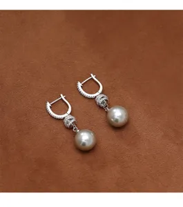 Elegantes pendientes largos de gota con perlas color champán e incrustaciones de circón