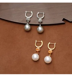 Elegantes pendientes de perlas con circonitas en acabados dorado y plateado, vista detallada.