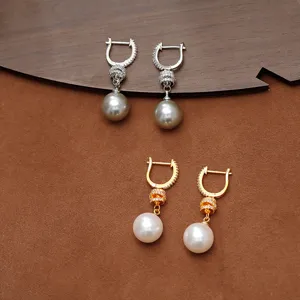 Pendientes largos de perlas refinados con circonitas brillantes en ganchos de oro y plata.