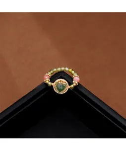 Detailed view of beaded ring with carved green jade fox charm in gold frame