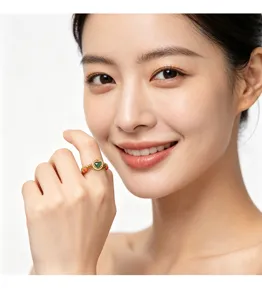 Detailed view of a vintage Chinese style beaded ring with green jade on a model's finger.