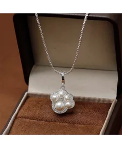 Detail van een kattenpoot ketting met parels en zirkonia in een luxe sieradendoosje