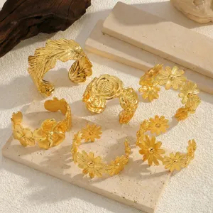 Detailansicht der 18K vergoldeten Edelstahl-Armreifen mit Blumenmustern.