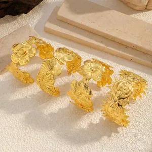 Detailansicht goldener Edelstahl-Armreifen mit Blumen- und Schmetterlingsmotiven