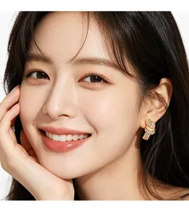 Detailed close-up of gold knot stud earrings with sparkling crystals on an Asian model