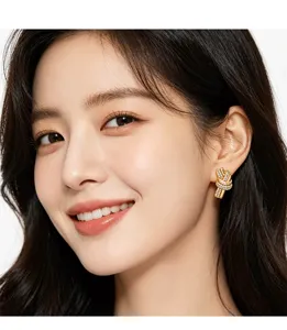 Close-up of sparkling gold knot earrings with micro-inlaid stones on an elegant model