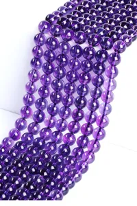 Close-up detail of polished natural purple amethyst crystal beads for jewelry making