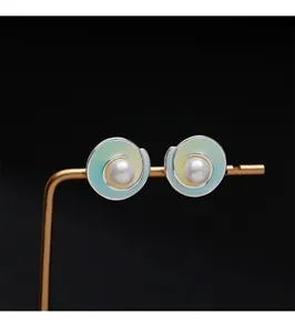 Vista detallada de pendientes de perla con diseño de espiral y esmalte degradado