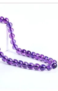 Close-up macro view of natural purple amethyst round beads for DIY bracelet jewelry making