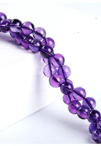 Macro view of polished natural purple amethyst round beads for DIY jewelry making.