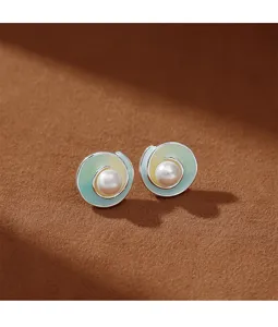Primer plano de elegantes pendientes de perlas con un suave acabado degradado.