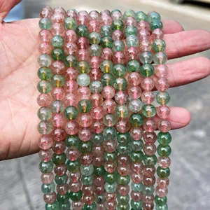 Vista dettagliata di perle in quarzo fragola naturali verdi e rosa per gioielli fatti a mano.