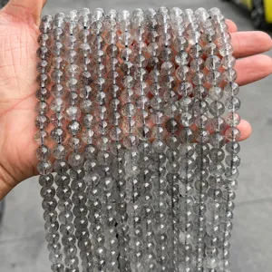 Primo piano di perle di quarzo traslucido naturale con inclusioni nere per gioielli