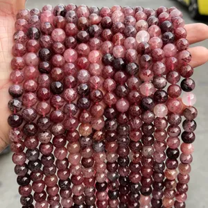 Vista macro di perle tonde di quarzo fragola naturale per la creazione di gioielli