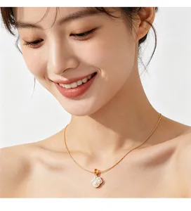 Detail van gouden kattenpoot hanger ketting met parels op een Aziatisch model