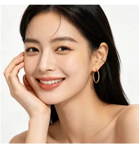 Asiatisches Model mit klassischen großen goldenen Kreolen für einen eleganten Look.