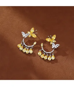 Vista detallada de alta calidad de elegantes pendientes de mariposa con circonitas amarillas