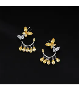 Detalle de pendientes de mariposa con gotas de circón amarillo brillante