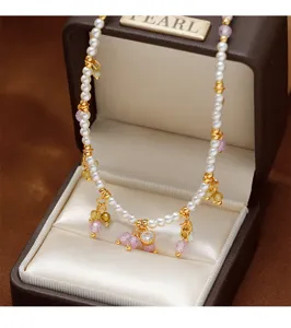 Nahaufnahme einer eleganten Rundperlenkette mit lila und gelben Edelsteinanhängern