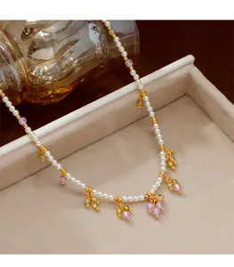 Detailansicht einer kleinen Rundperlenkette mit lila und gelben Perlenanhängern.