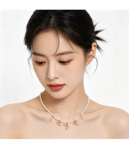Elegantes französisches Perlen-Choker-Halsband mit rosa Perlenanhängern an einem Model.
