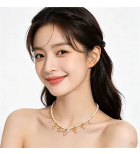 Elegante kleine Perlenkette mit rosa und goldenen Anhängern am Hals des Models
