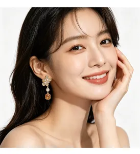 Detalle de los elegantes pendientes de diseño con flores y perlas en una modelo