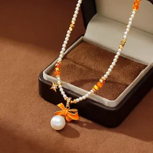Elegante Halskette mit orangefarbenem Emaille-Schleifenanhänger und Perlen.
