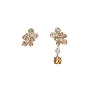 Elegantes pendientes de flores asimétricos dorados con perlas y piedras champagne