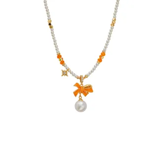 Elegante Halskette mit orangefarbener Emaille-Schleife und feinen weißen Perlenketten