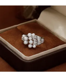 Close-up of elegant pearl ring with zircon details in a brown velvet jewelry box
