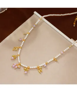 Nahaufnahme einer eleganten kleinen Perlenkette mit bunten Kristallanhängern.