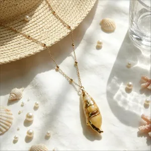 Close-up detail of ocean resort style conch shell pendant necklace on white fabric background.