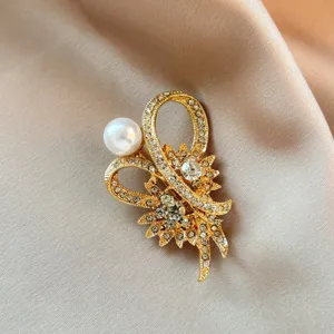 Close-up detail shot of exquisite gold-tone rhinestone and pearl floral brooch accessory.