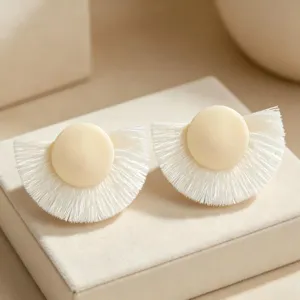 Gros plan sur des boucles d'oreilles frangées blanches, style chic pour tous les jours.