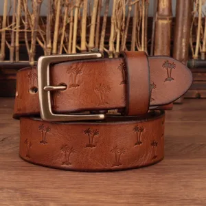 Detail view of retro men genuine leather belt with palm tree embossed pattern and copper buckle.