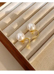 Elegant retro mosquito coil ear clips with large pearls on a beige jewelry tray