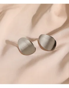 Boucles d'oreilles géométriques minimalistes argentées avec texture en métal brossé mat.