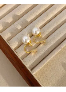 Detailed macro shot of elegant large pearl clip-on earrings on beige velvet jewelry tray