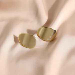 Boucles d'oreilles clous géométriques minimalistes en métal doré brossé sur soie champagne