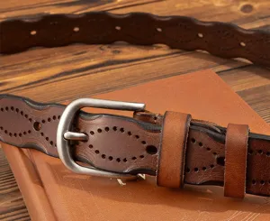 Close-up detail of retro brown genuine leather women belt with punched hollow pattern pin buckle.