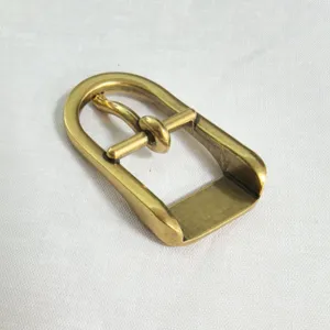Close-up detail shot of a golden zinc alloy semi-circle pin buckle for luggage and shoes.