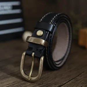Primo piano dettagliato della cintura in vera pelle nera con fibbia in ottone vintage.