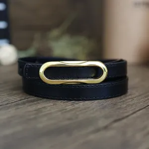 Black leather belt for women with a stylish gold oval buckle minimalist design thin strap.