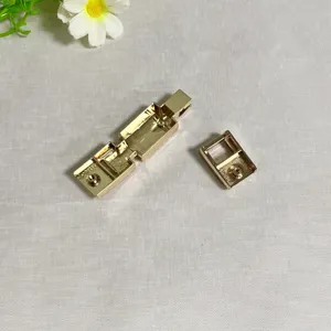 Golden metal bag lock hardware detail shot, replacement clasp buckle component accessory.